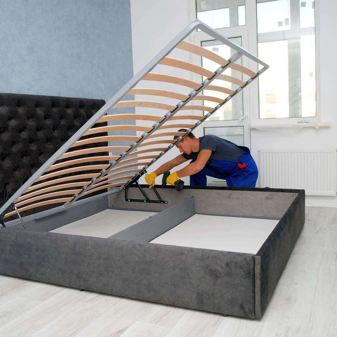 Egy bútorasztalos ágy összeszerelés közben Budapesten