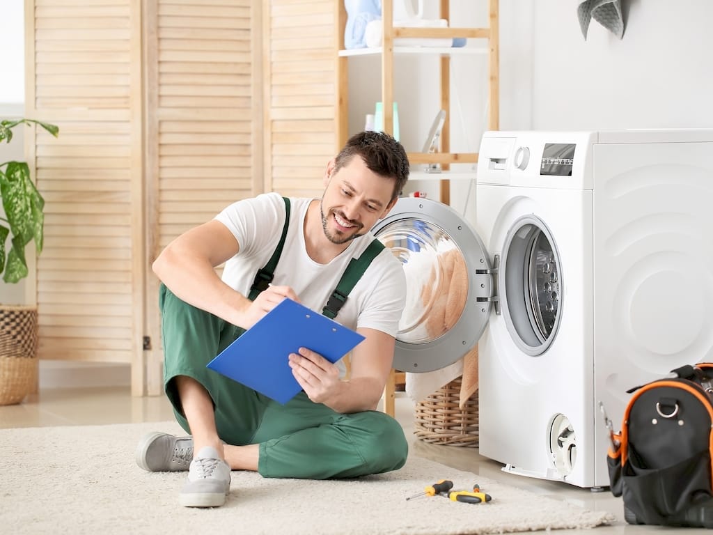 Egy mosógép szerelő mosógép javítás közben Budapesten