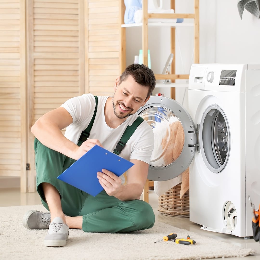 Egy mosógép szerelő mosógép javítás közben Kaposváron
