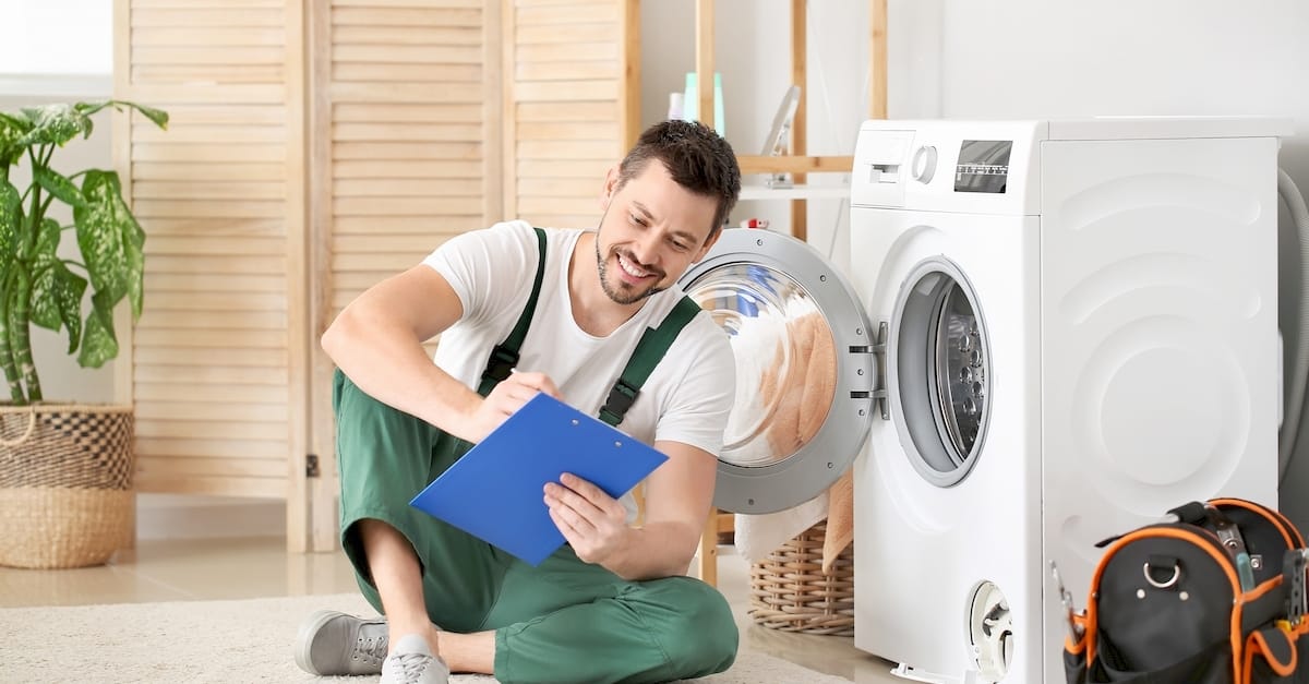 Egy mosógép szerelő mosógép javítás közben Kecskeméten