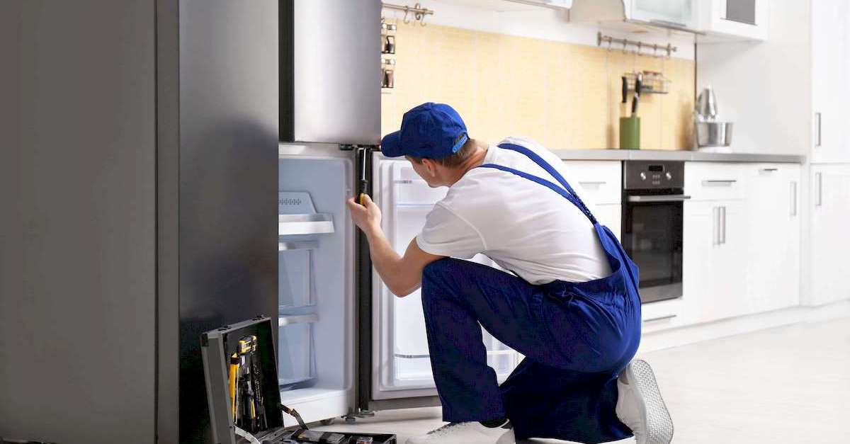 Egy hűtőgép szerelő hűtőszekrény javítás közben Tatabányán